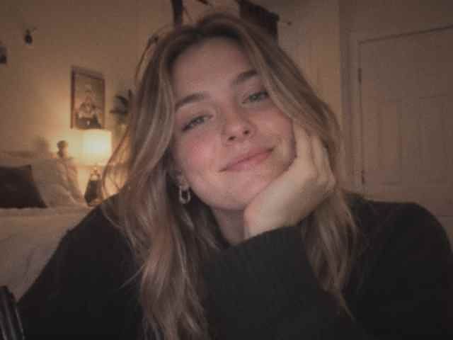 A songwriter smiling, pen in hand