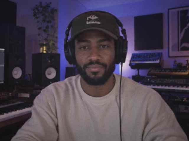A producer at his keyboard and DAW, headphones on